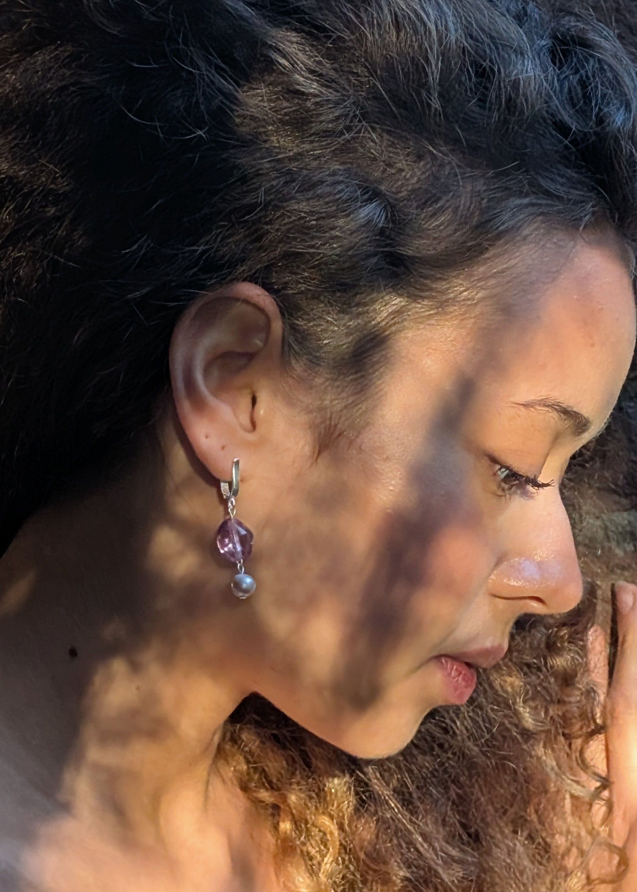 Close-up of a person with sunlit hair and earrings