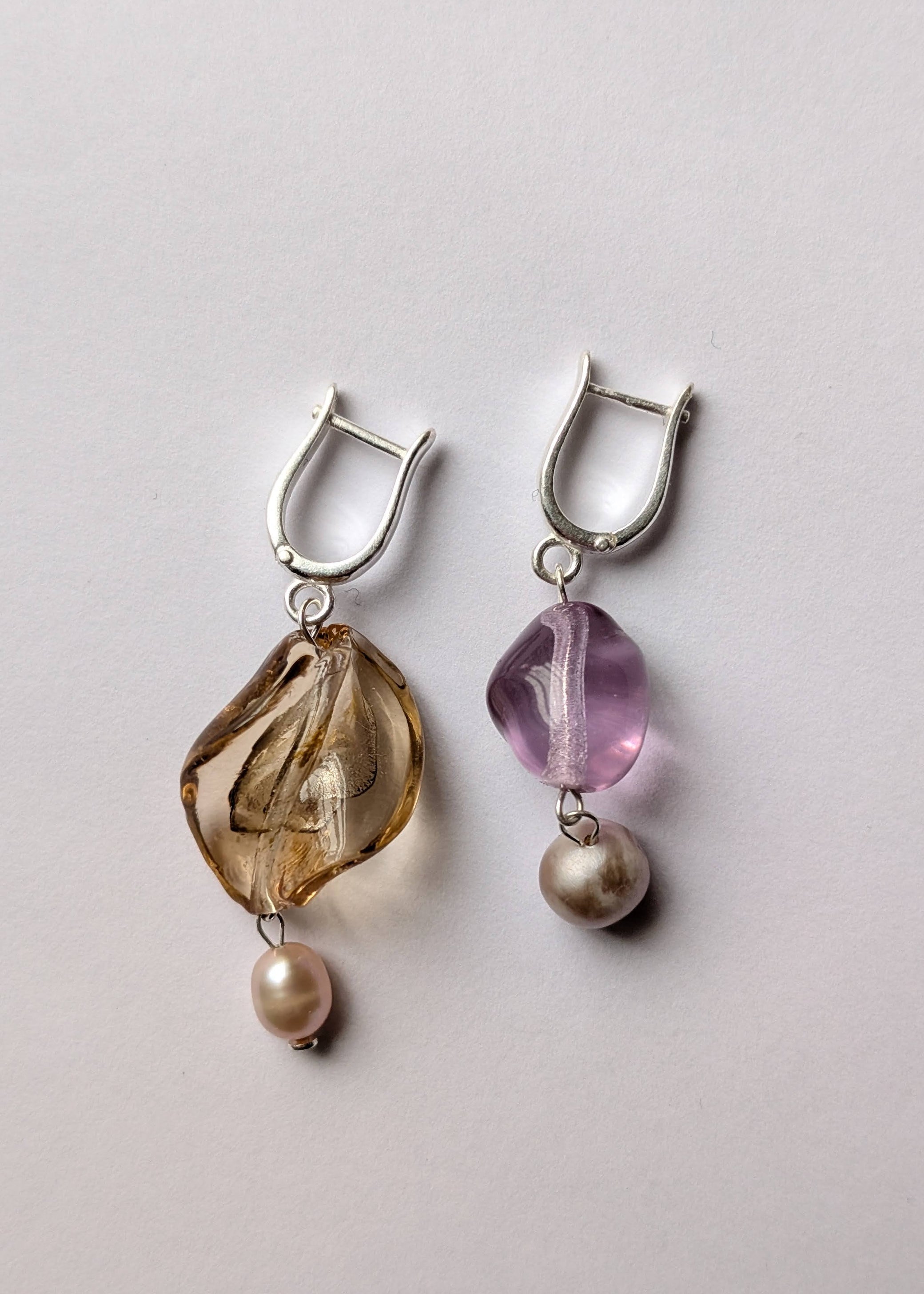 Pair of earrings with natural elements on a light gray background