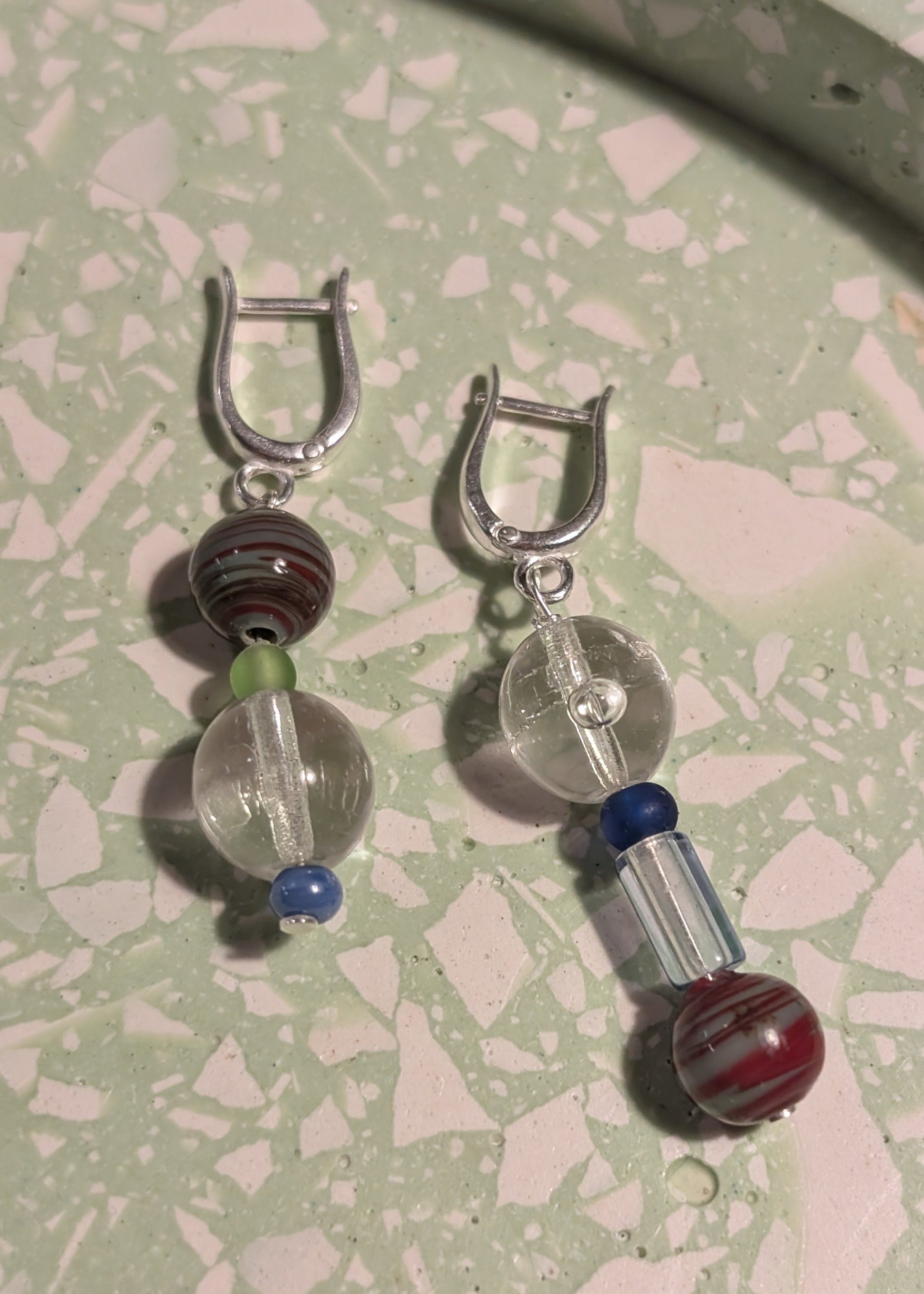 Pair of earrings with glass beads on a textured surface