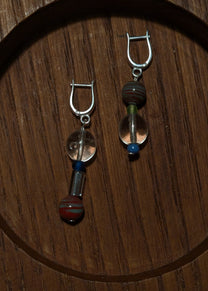 Pair of earrings with glass beads on a wooden surface