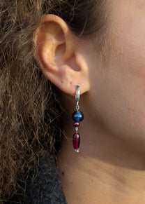 Close-up of an ear wearing a beaded earring with a blurred background