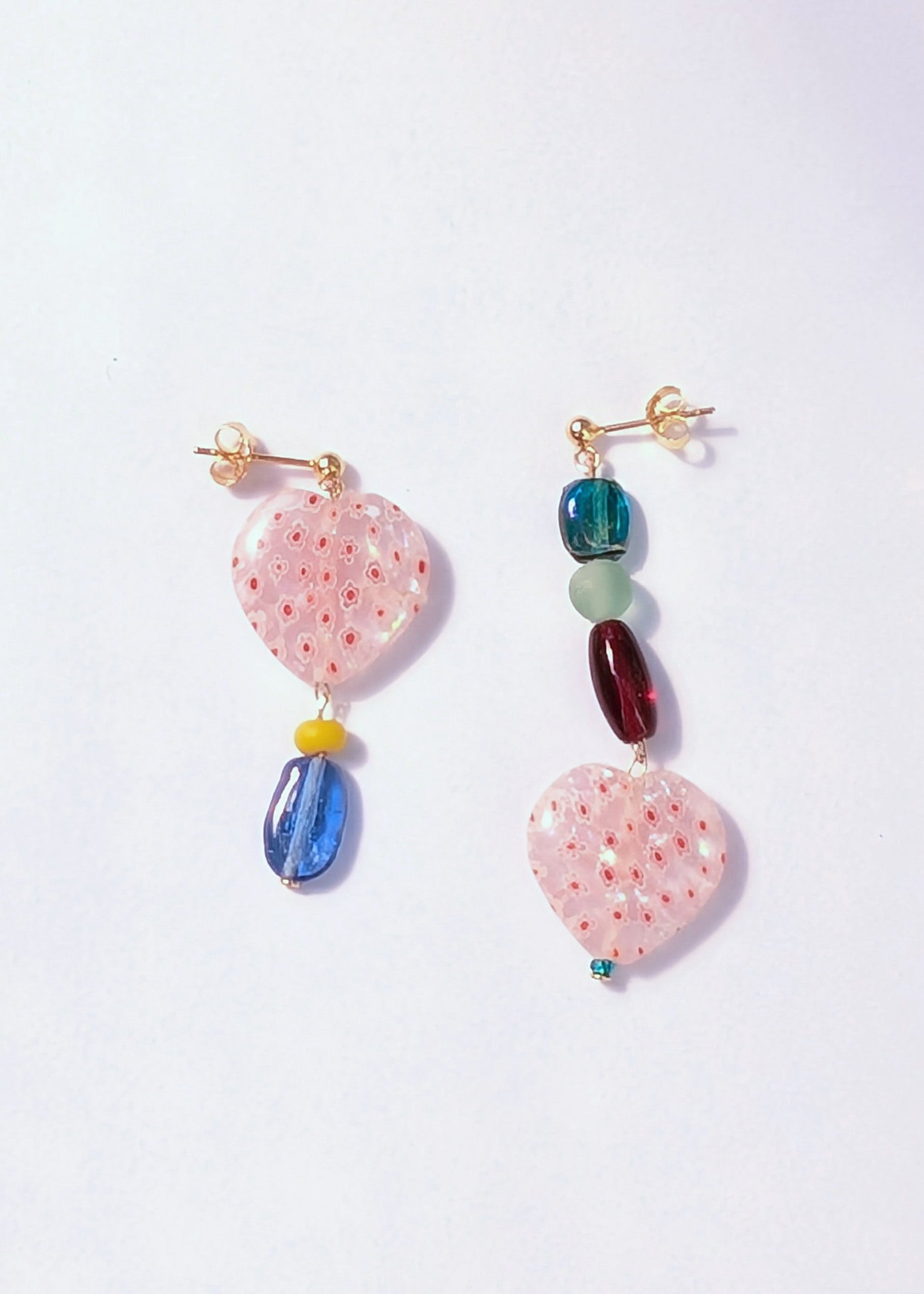 Pair of colorful earrings on a light purple background