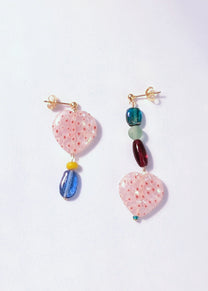 Pair of colorful earrings on a light purple background