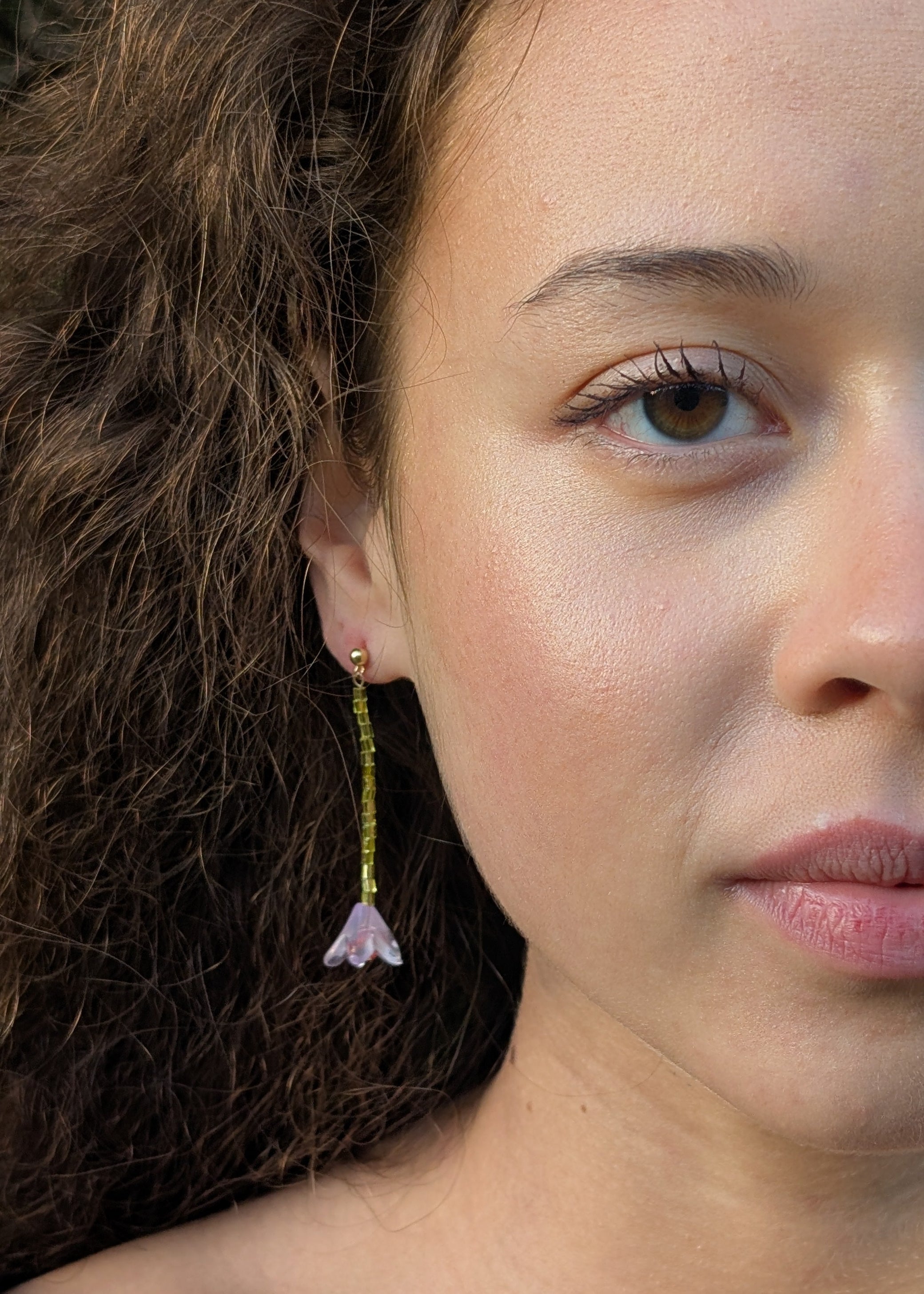 Close-up of a woman wearing a floral earring with a blurred background