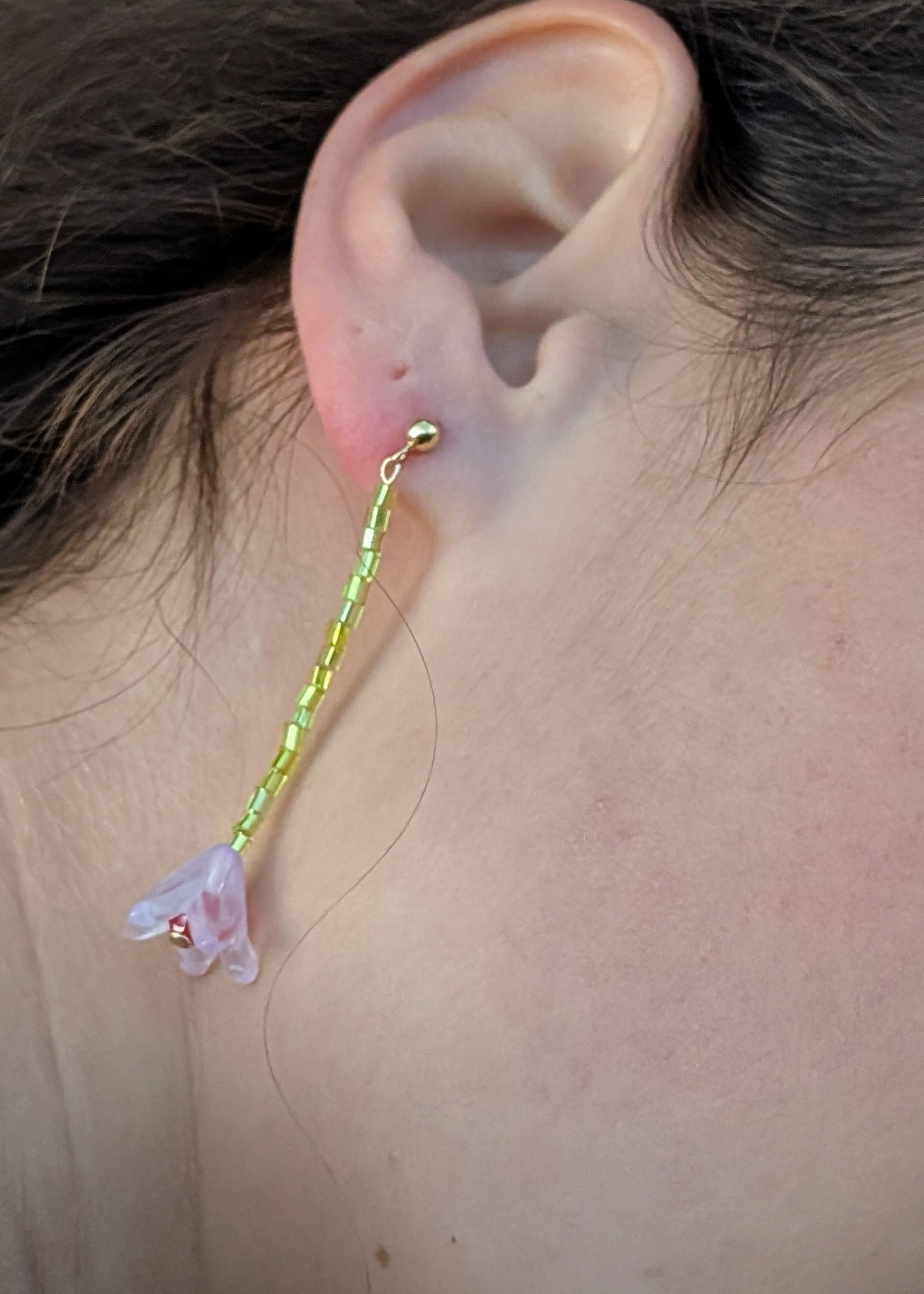 Close-up of an ear with a floral earring.