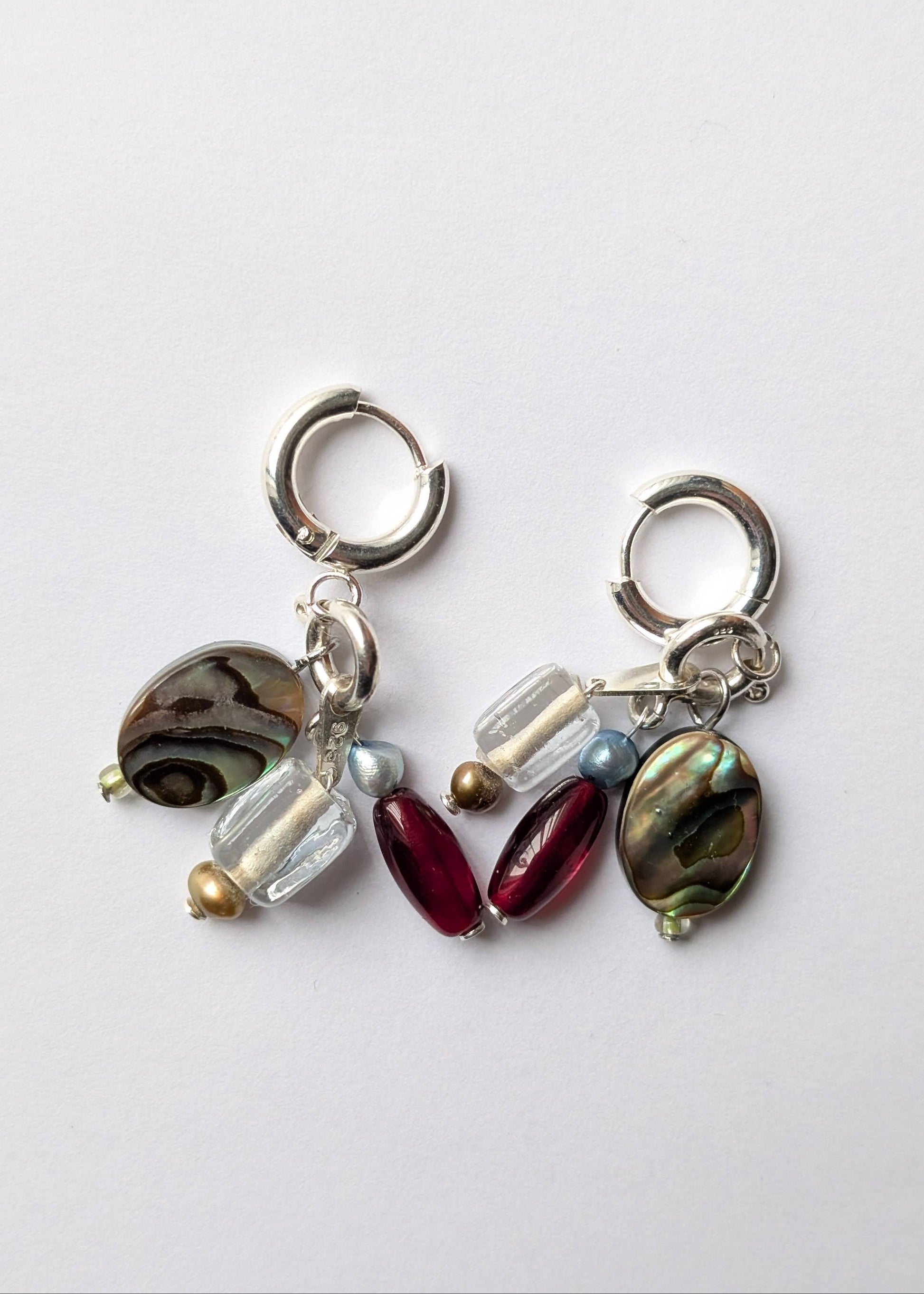Pair of earrings with various beads on a white background