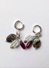 Pair of earrings with various beads on a white background