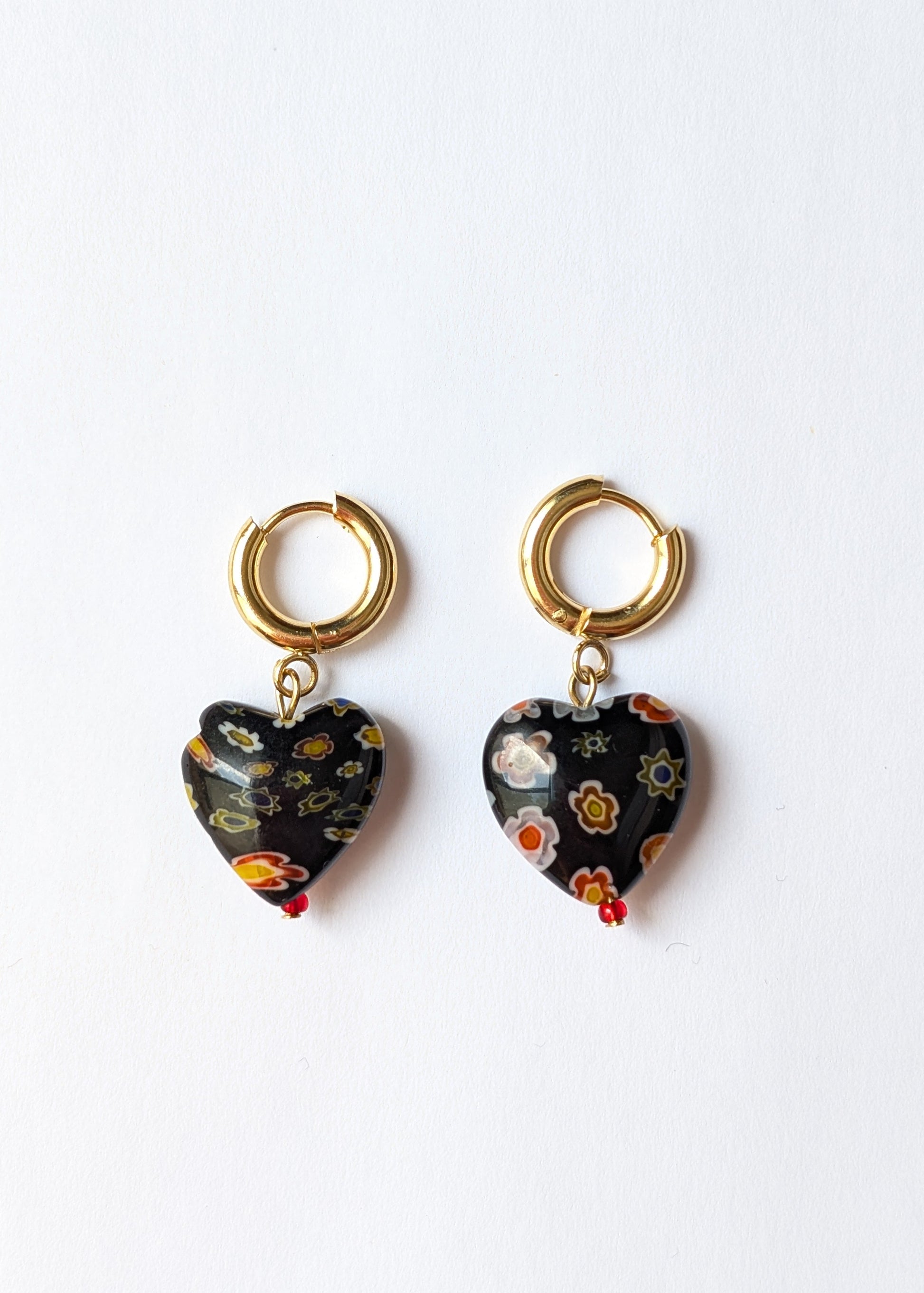 Heart-shaped earrings with gold hooks on a white background
