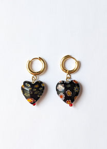 Heart-shaped earrings with gold hooks on a white background