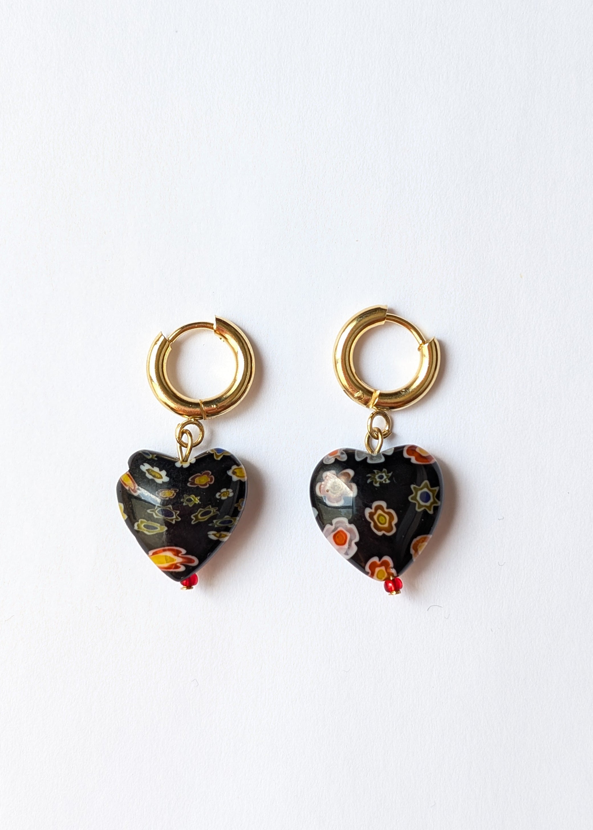 Heart-shaped earrings with gold hooks on a white background