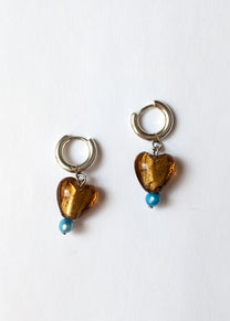 Pair of earrings with heart-shaped amber beads and blue beads on a white background