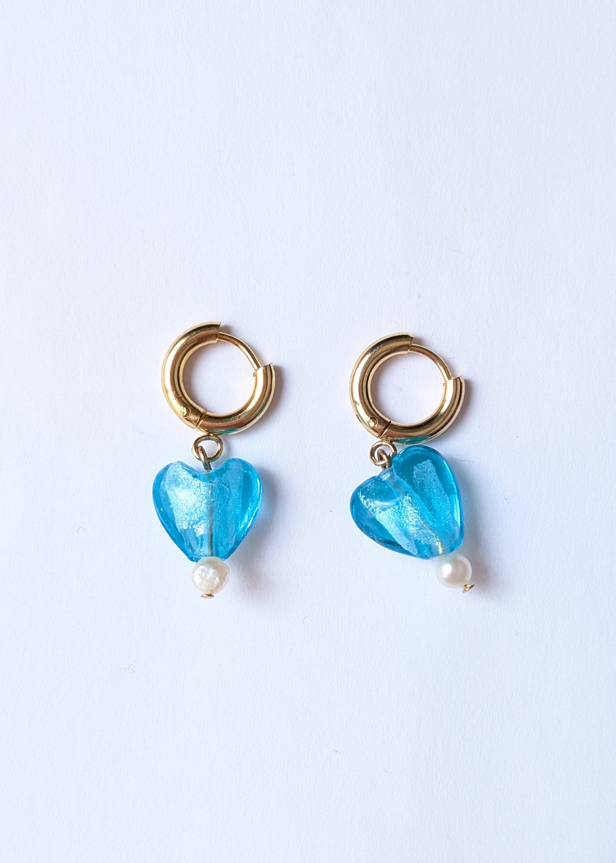 Pair of earrings with blue heart-shaped beads on a white background
