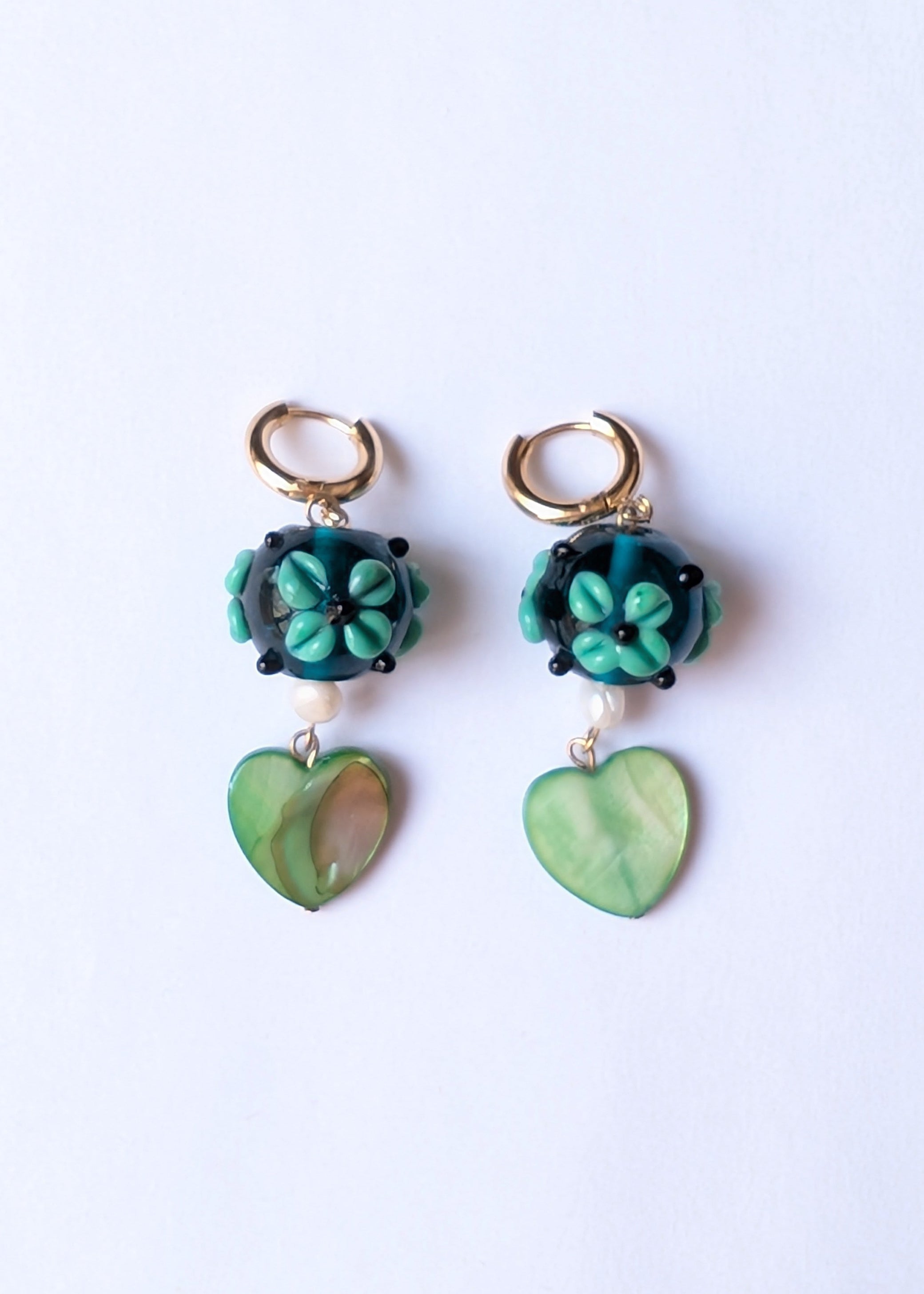 Pair of green floral earrings on a white background