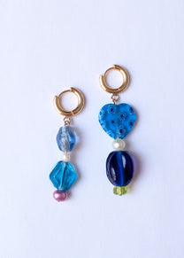 Pair of earrings with blue and gold beads on a white background