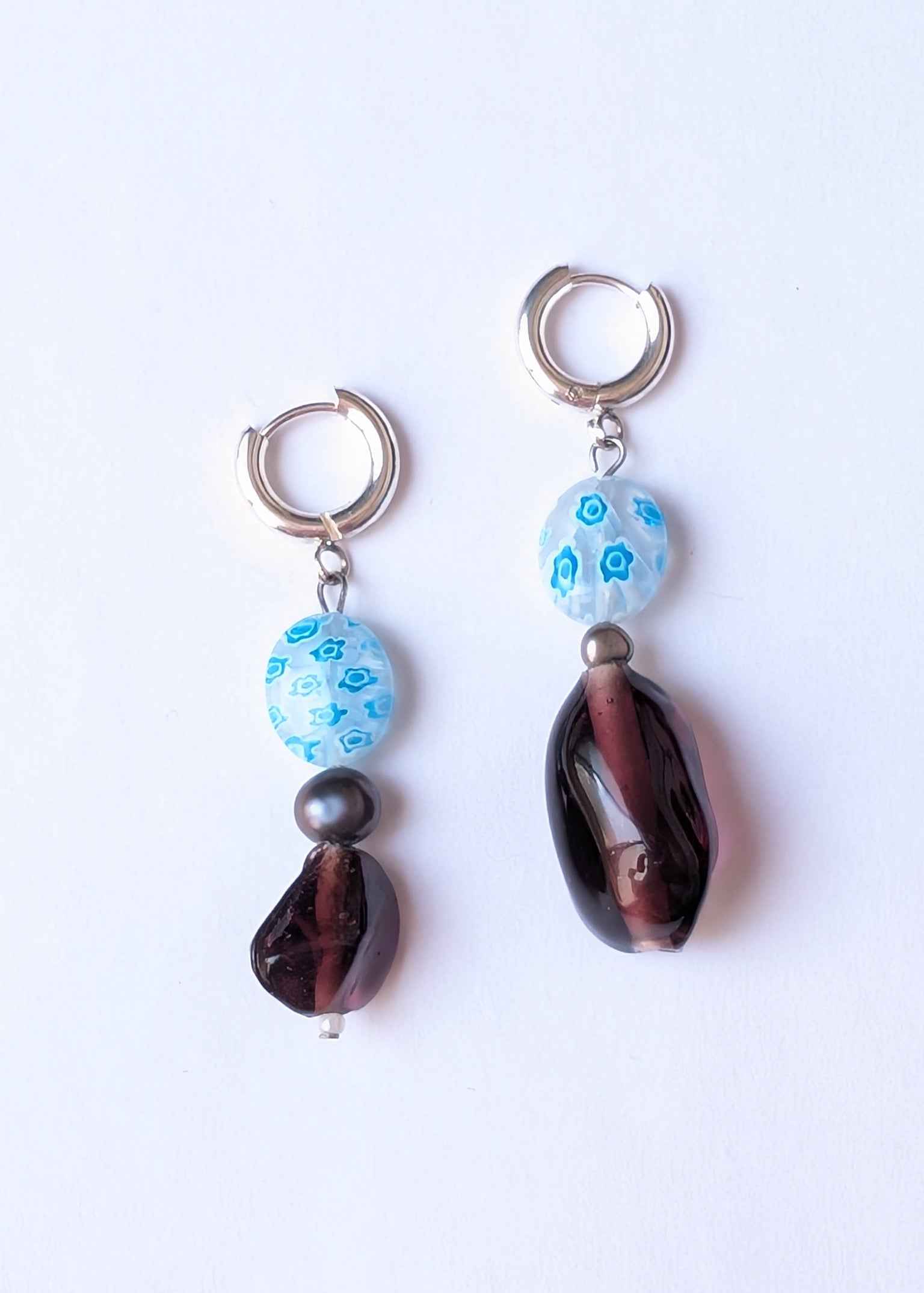 Pair of earrings with blue and brown beads on a white background