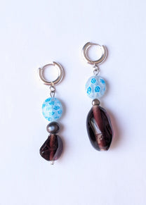Pair of earrings with blue and brown beads on a white background