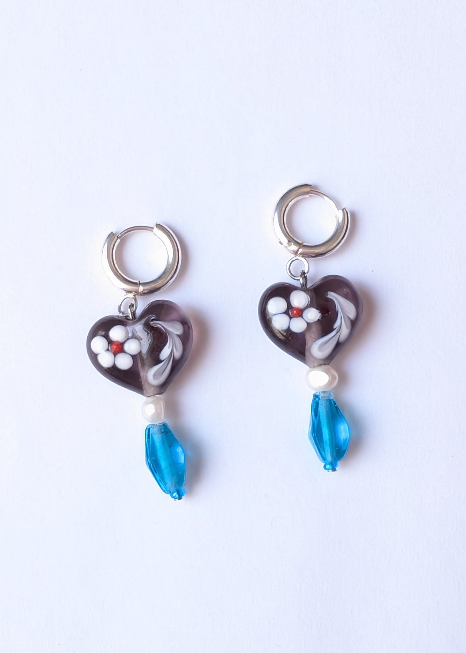 Heart-shaped earrings with blue beads on a white background