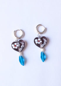 Heart-shaped earrings with blue beads on a white background