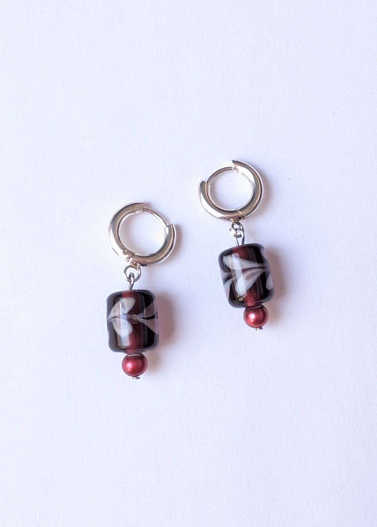 Pair of earrings with marbled beads on a white background