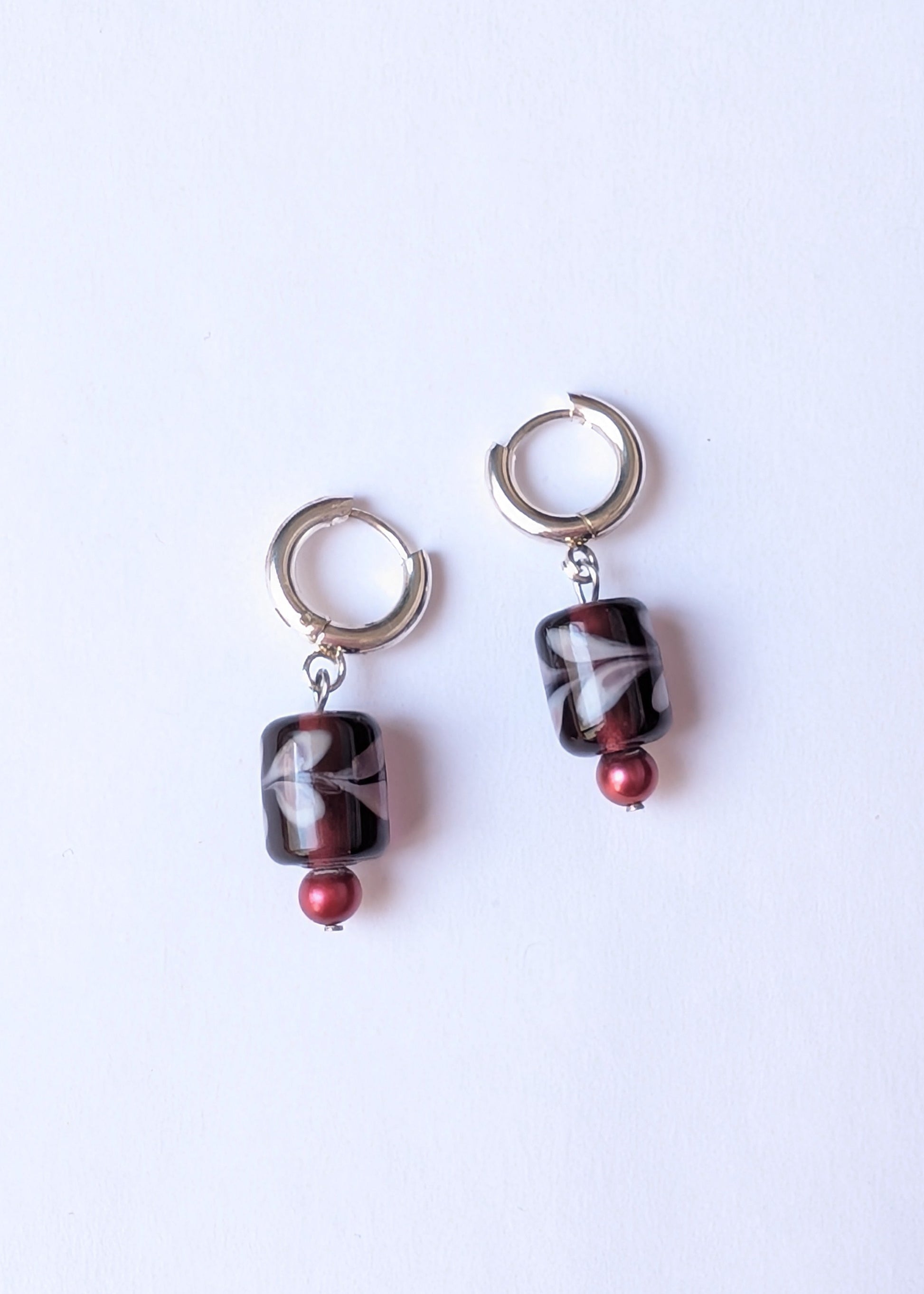 Pair of earrings with marbled beads on a white background