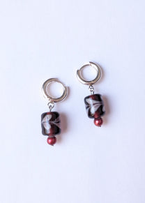 Pair of earrings with marbled beads on a white background