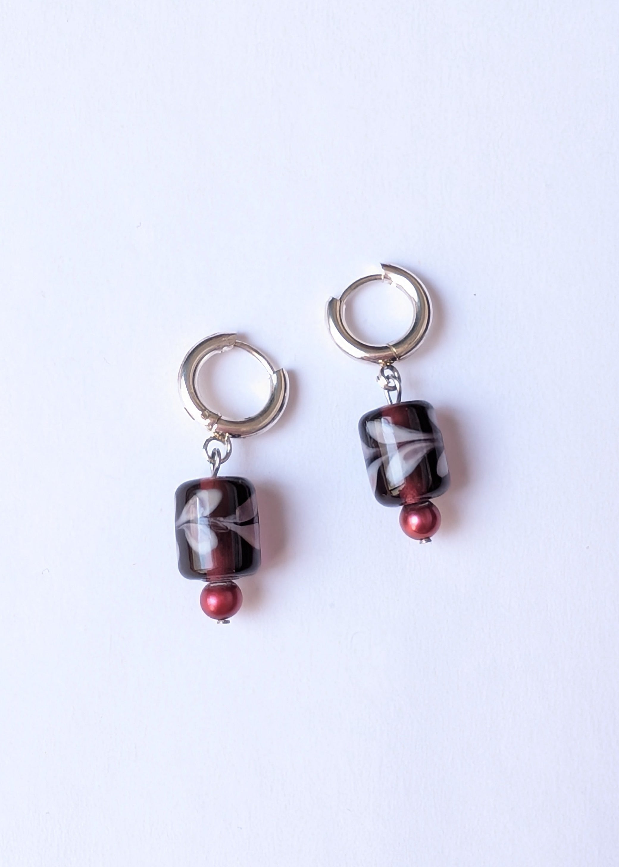 Pair of earrings with marbled beads on a white background