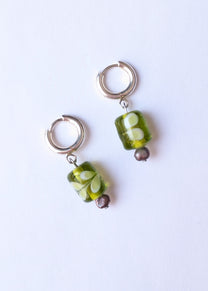 Pair of earrings with green and brown beads on a white background