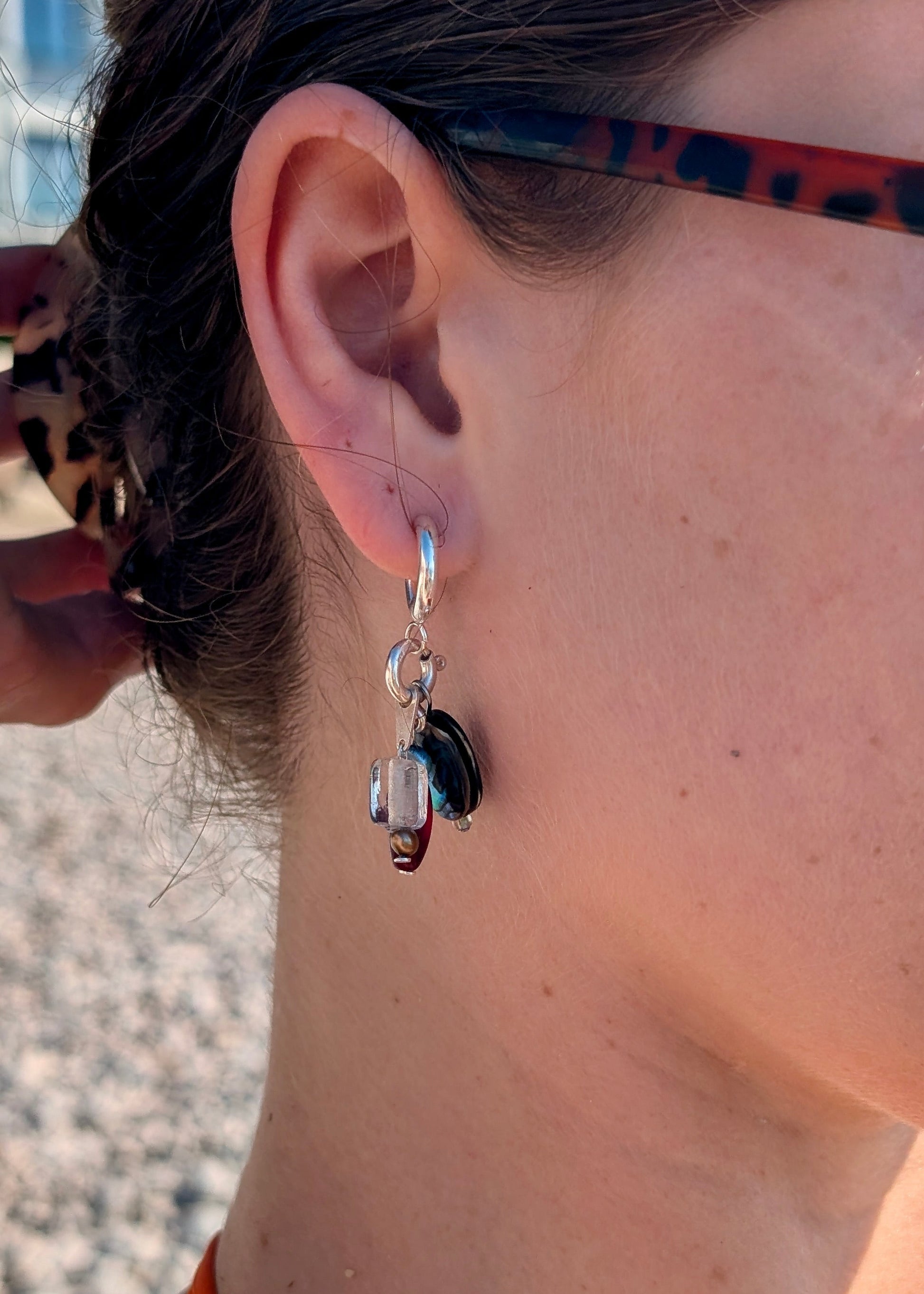 Close-up of an earring worn by a person with a blurred background